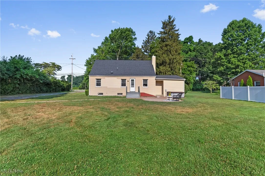 Back of house with a chimney, a patio, and entry steps