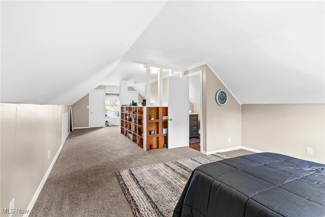 Bedroom with carpet flooring and vaulted ceiling