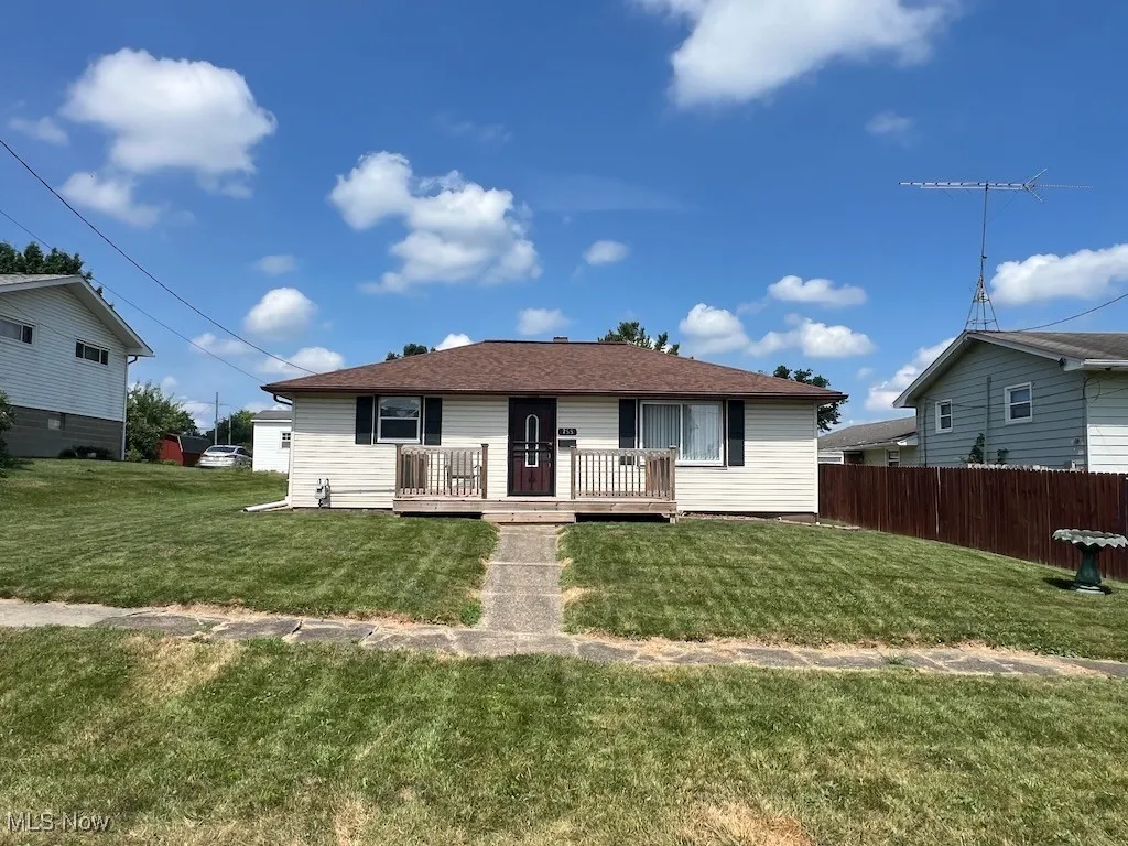 Single story home featuring a deck and a shingled roof