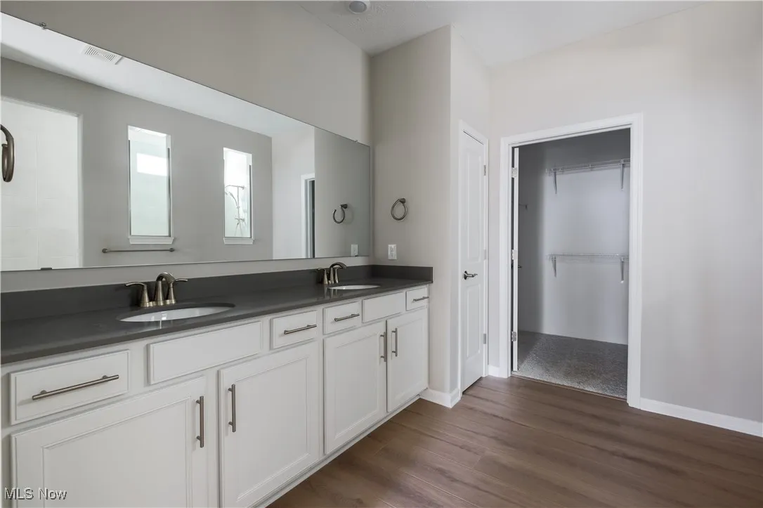 Owner's en-suite bath includes a dual vanity with quartz countertops.