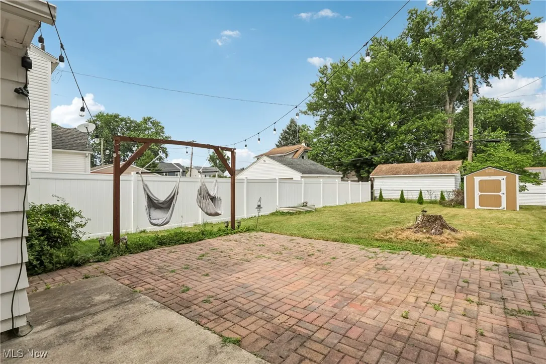 Fenced backyard featuring a patio and a storage shed