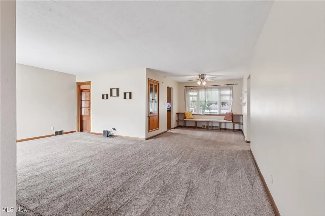 Spare room featuring carpet floors and ceiling fan