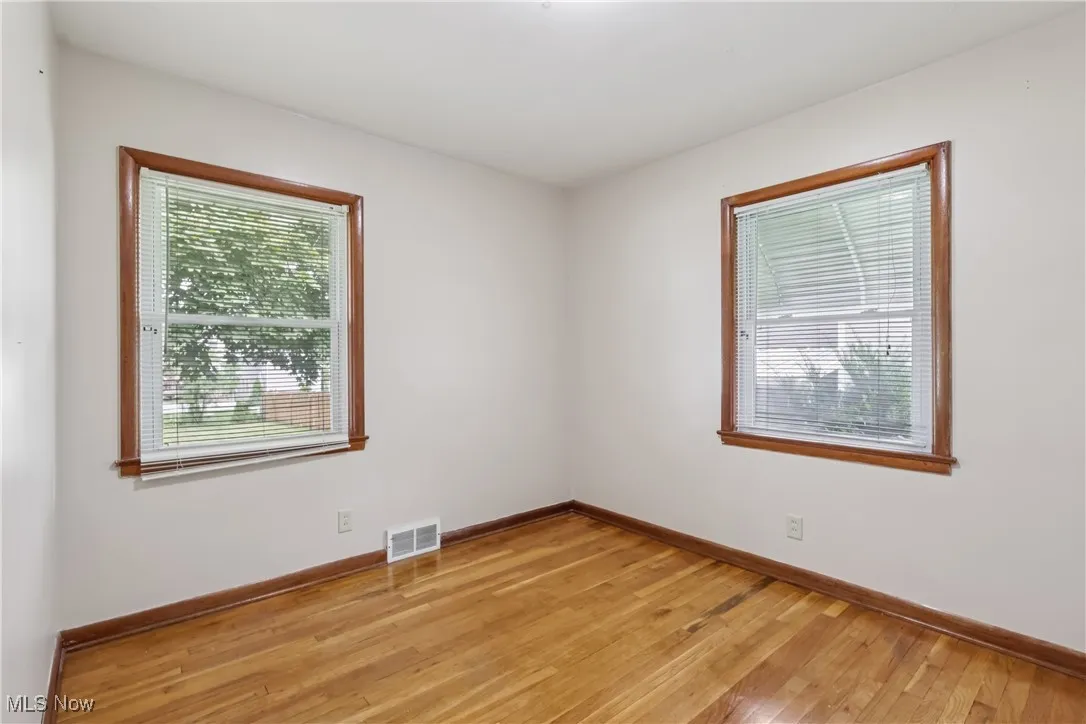 Empty room with light wood-style flooring and baseboards