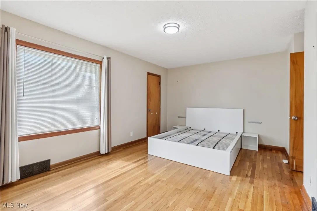 Unfurnished bedroom featuring light wood finished floors and baseboards