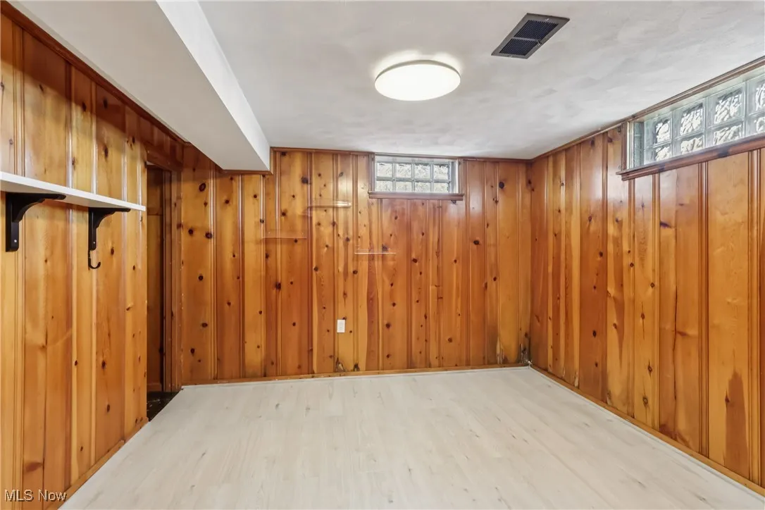 Below grade area featuring wood finished floors and wooden walls