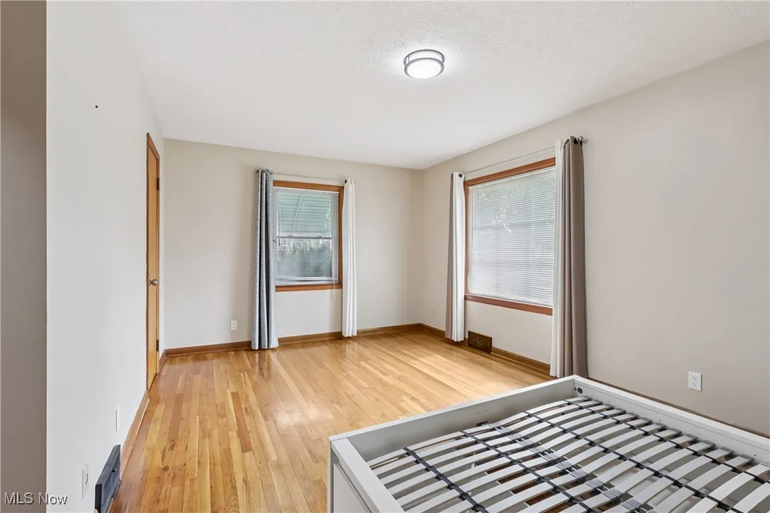 Unfurnished bedroom with light wood-type flooring and a textured ceiling