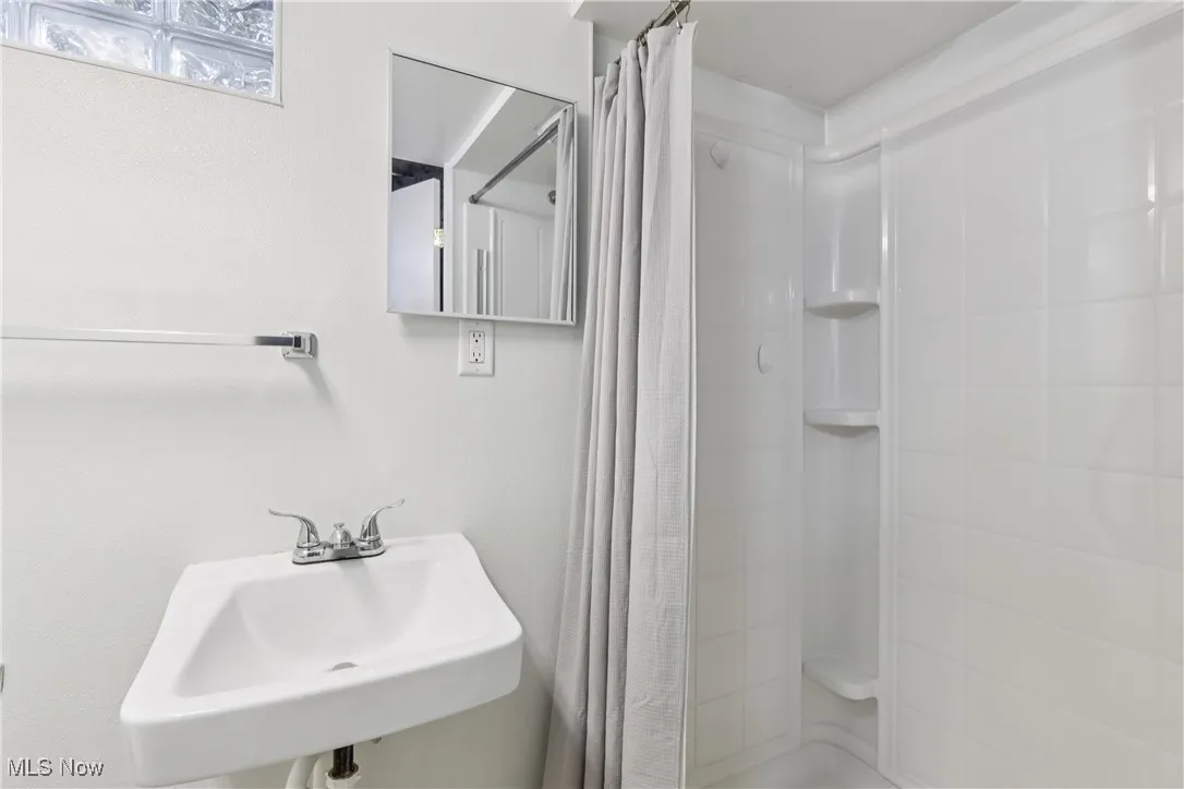 Full bathroom with a shower with shower curtain and a sink