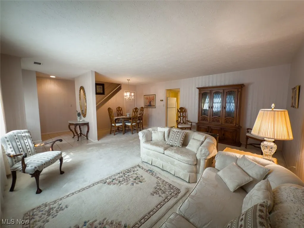 Carpeted living area featuring the foyer and dining area
