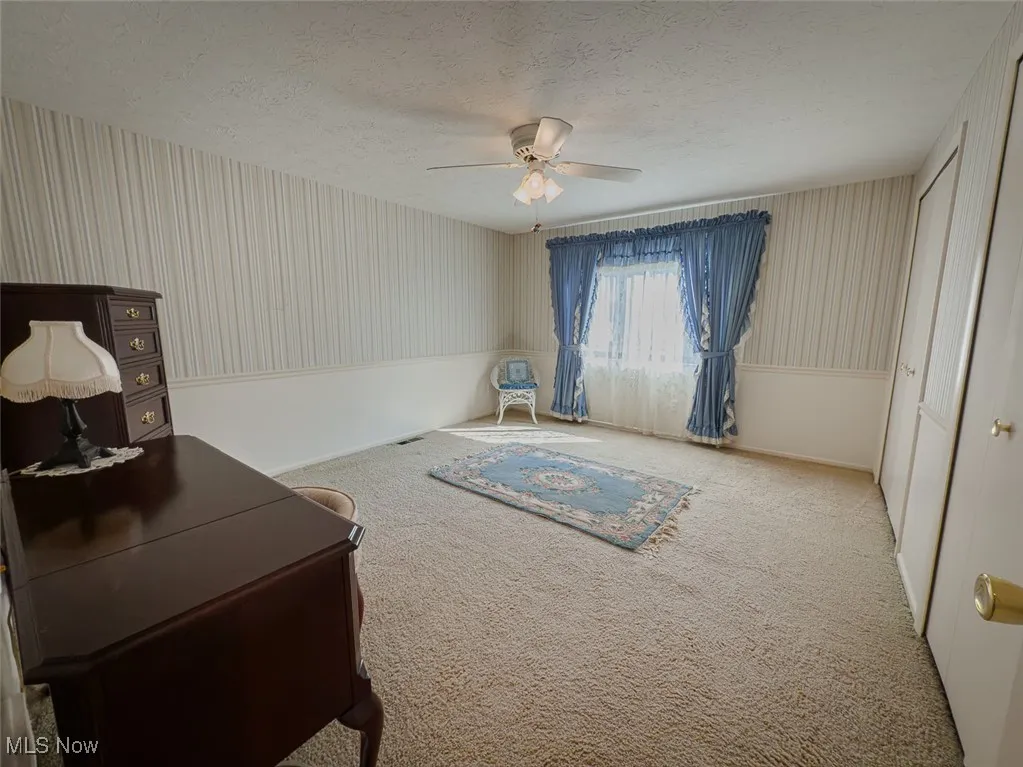 Bedroom featuring ceiling fan and carpet floors