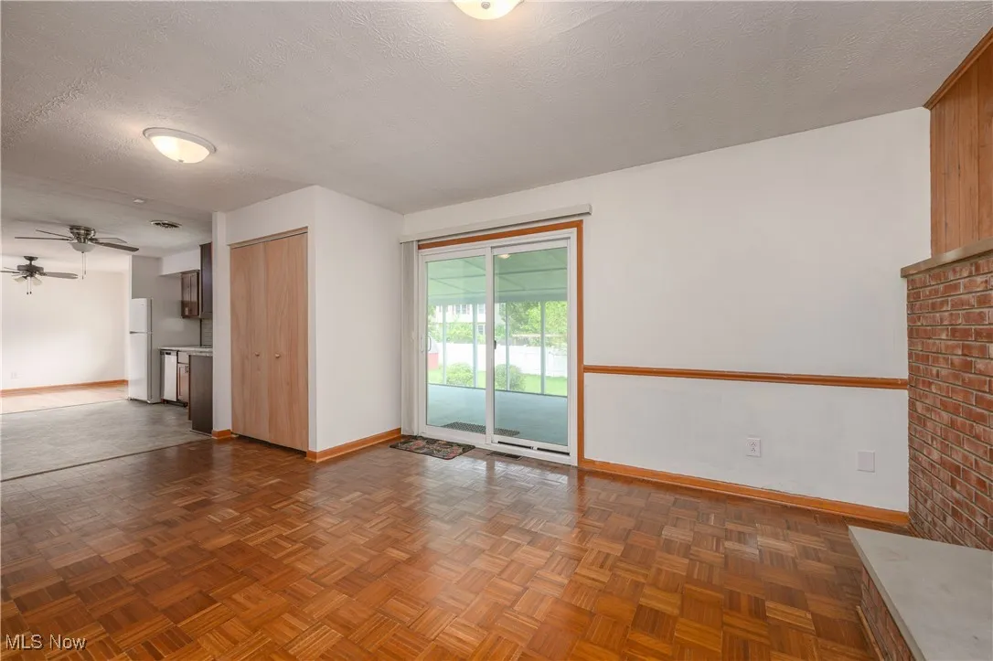Unfurnished living room with ceiling fan and a textured ceiling