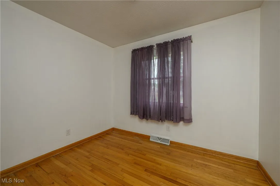 Empty room with light wood-style flooring and baseboards