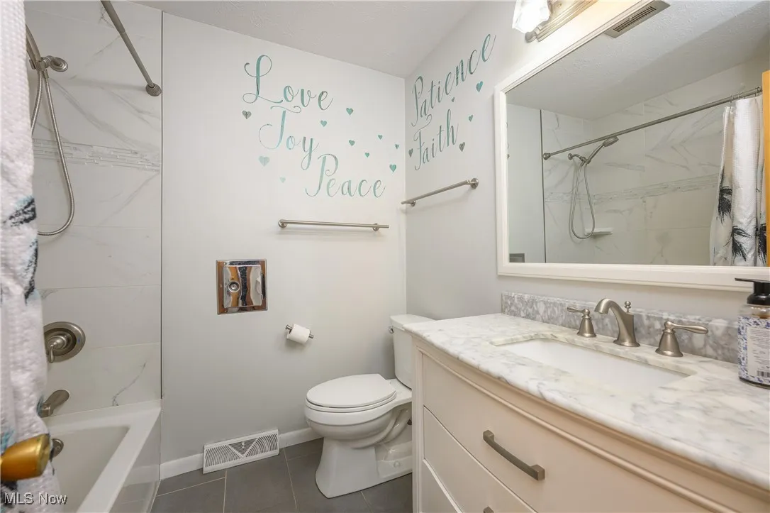 Bathroom featuring vanity, tile patterned floors, and shower / bathtub combination with curtain