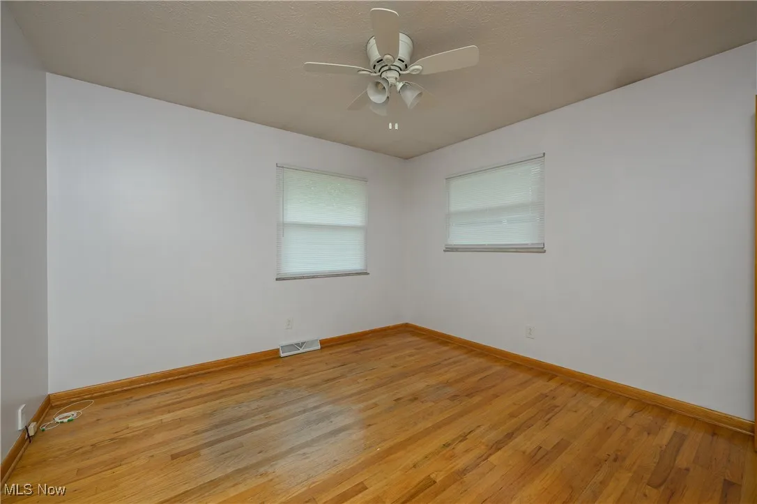 Spare room featuring light wood-type flooring and ceiling fan