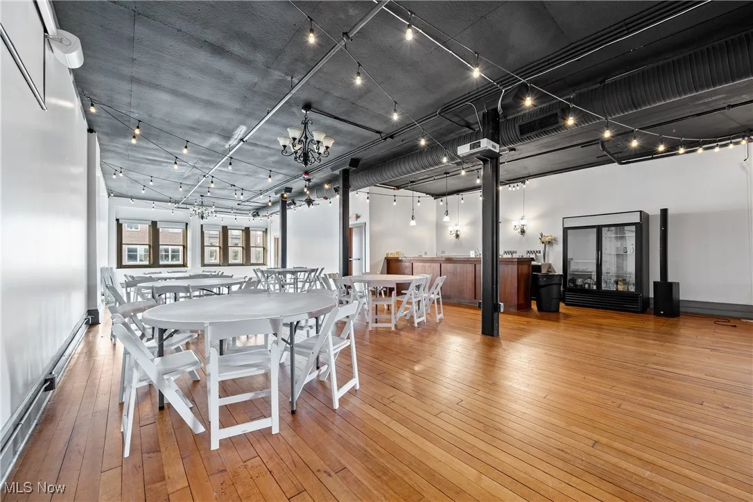 Dining room with a baseboard radiator, hardwood / wood-style floors, and a chandelier