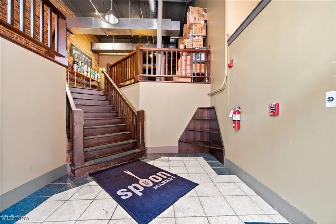Stairway with tile patterned flooring and a high ceiling