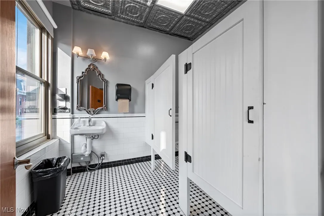 Bathroom featuring plenty of natural light and tile walls