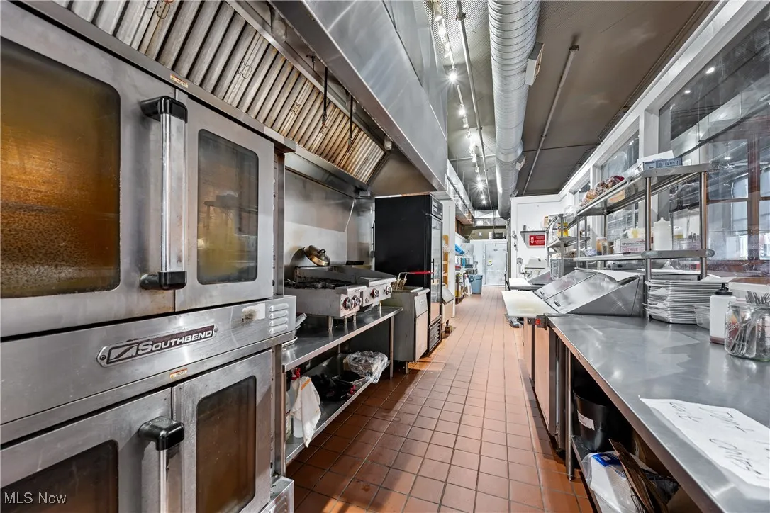 Kitchen with stainless steel countertops, stainless steel double oven, and tile patterned flooring