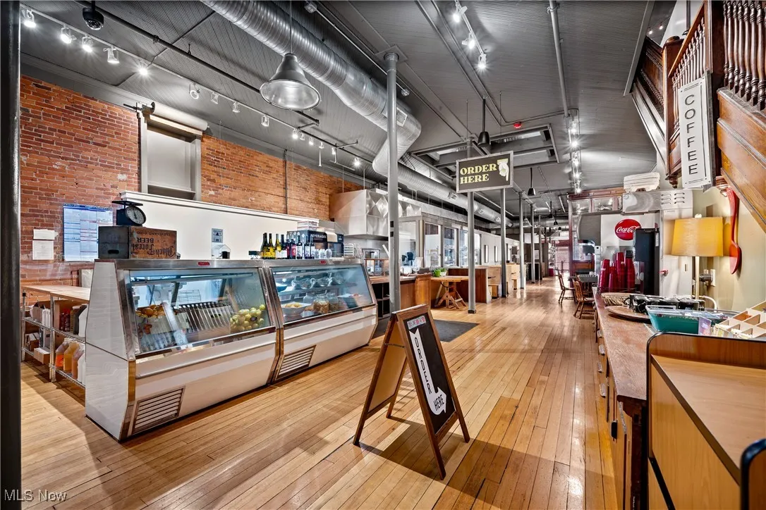 Misc room with hardwood / wood-style flooring and brick wall