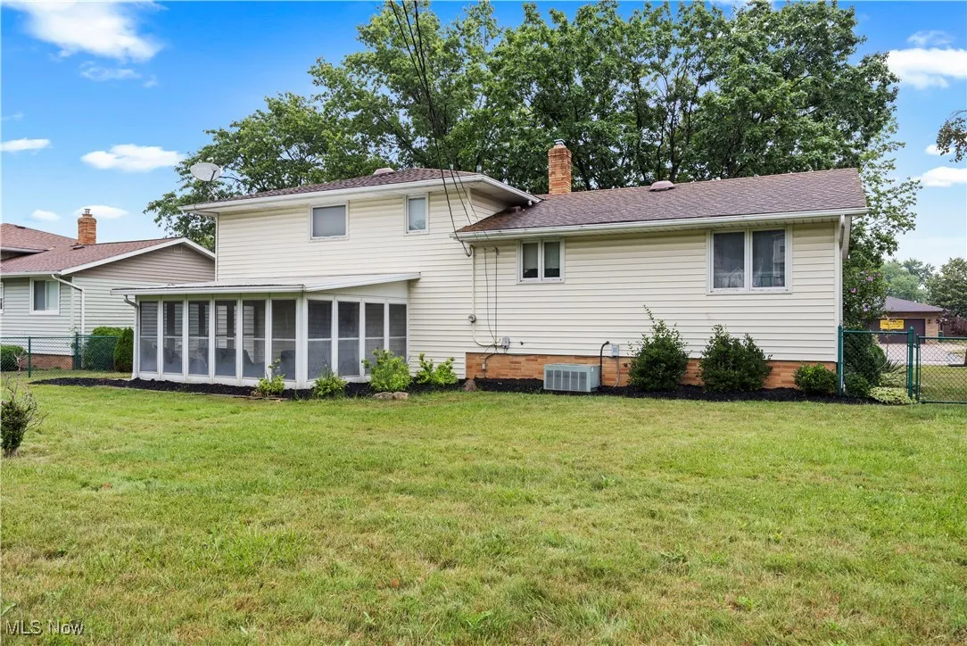 Back of property featuring a sunroom and a chimney