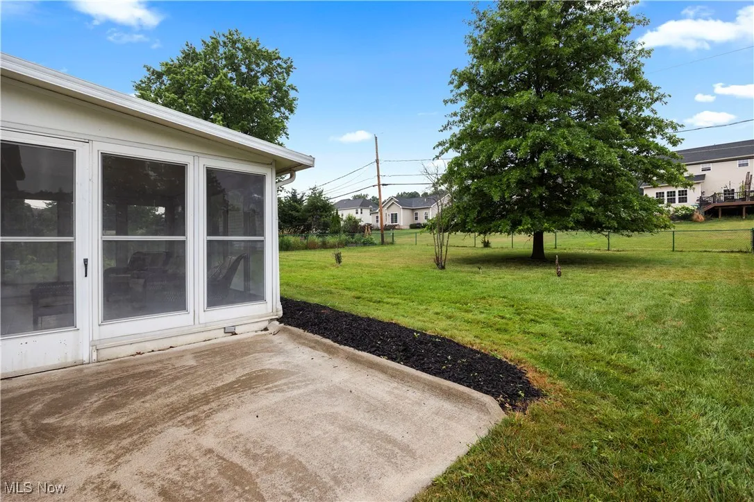 View of grassy yard with a patio area