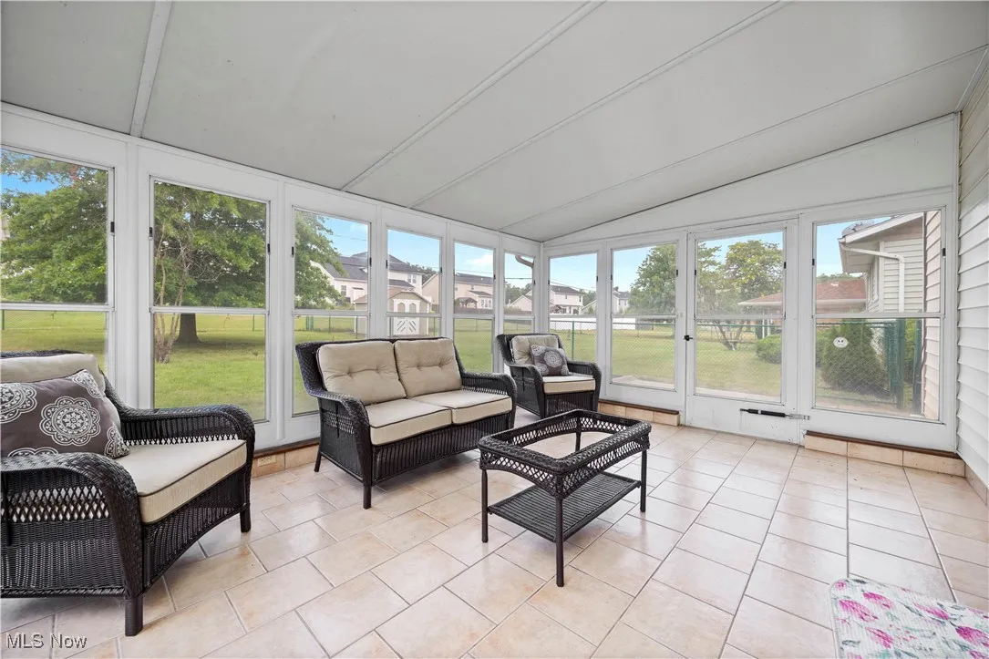 Sunroom with french doors, lofted ceiling, an outdoor hangout area, and healthy amount of natural light