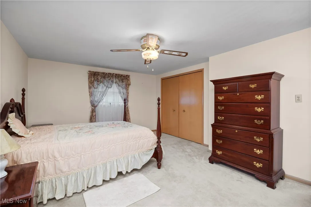 Bedroom featuring light carpet, a closet, and ceiling fan