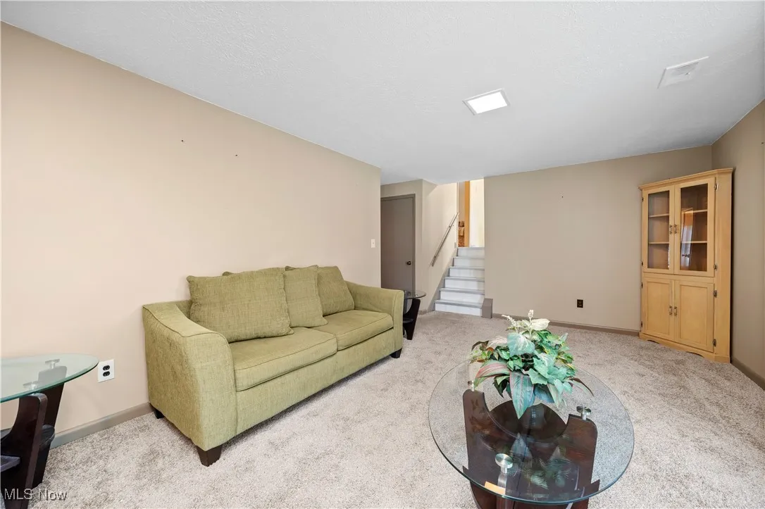 Family room with carpet flooring and stairs