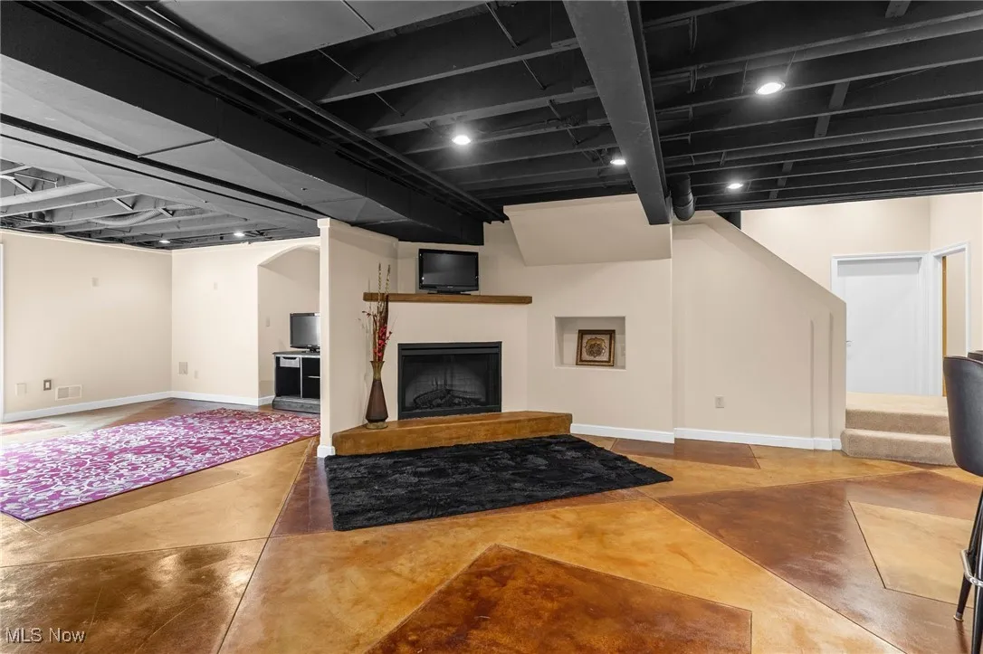Finished Lower Level with a fireplace with raised hearth and stairs