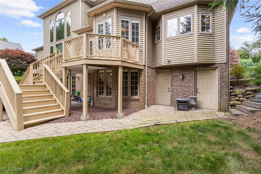 Rear view of house with stairway, a patio area, and a deck