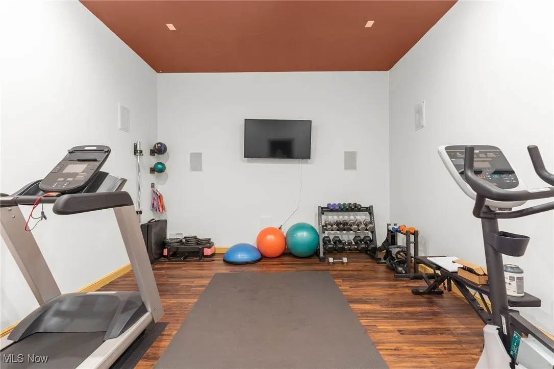 Exercise room featuring dark wood-style flooring