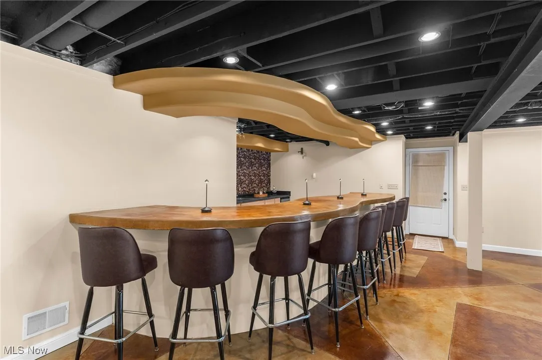 Indoor wet bar featuring concrete floors