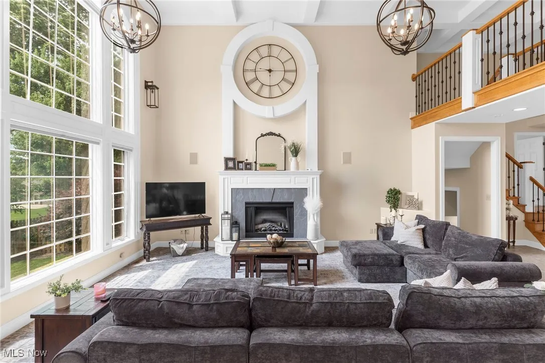 Great Room featuring a coffered ceiling, stairway, and a high end fireplace