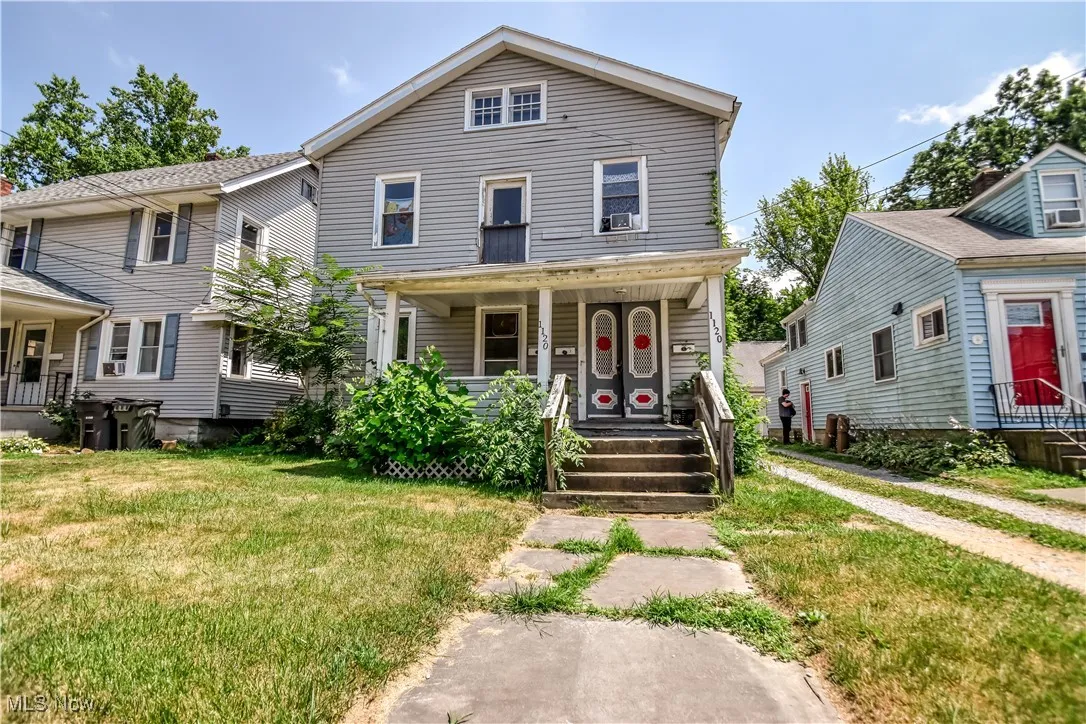 View of front of house with covered porch and a front lawn