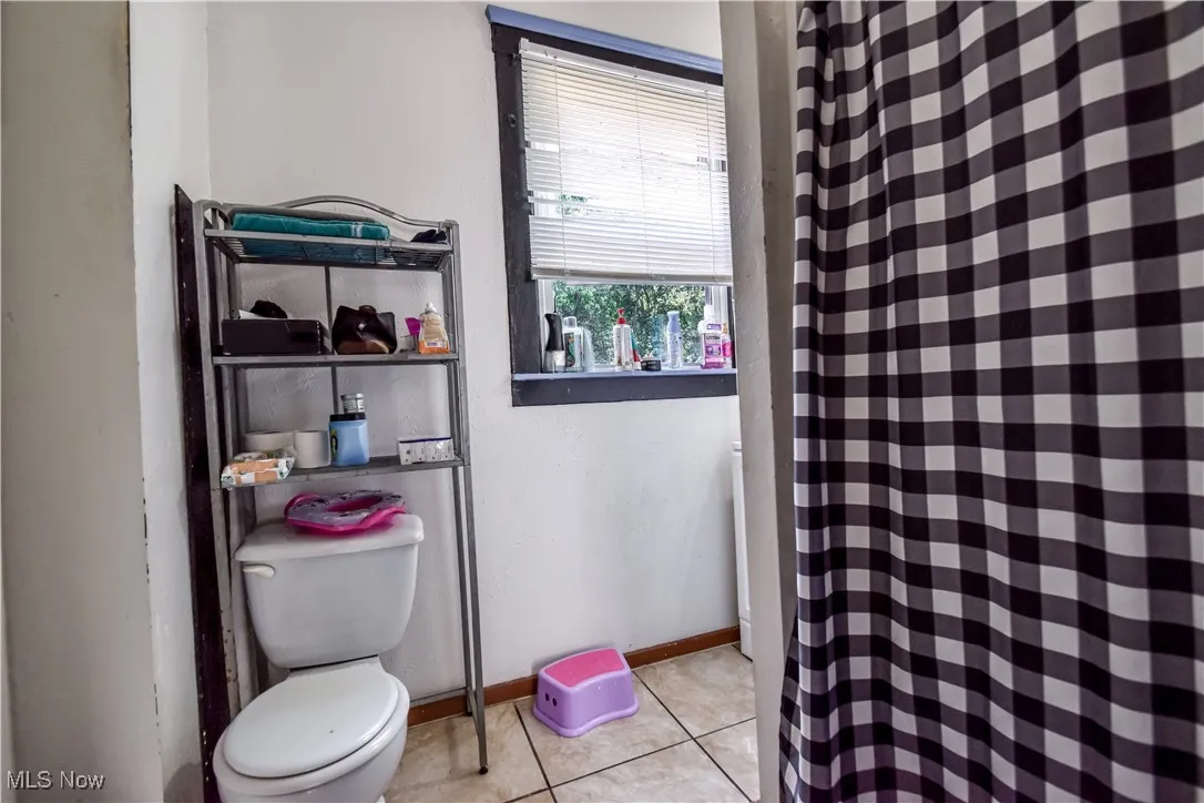 Bathroom with tile patterned floors and a shower with shower curtain
