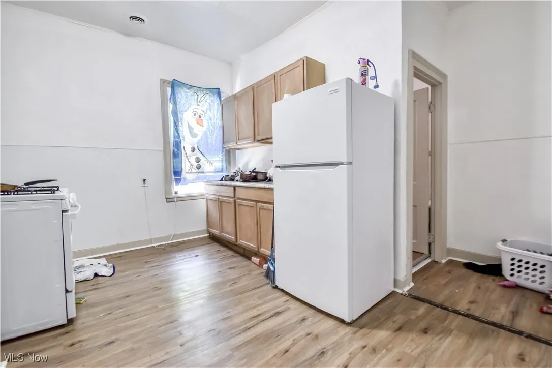 Kitchen featuring white appliances, light wood-style floors, and light countertops