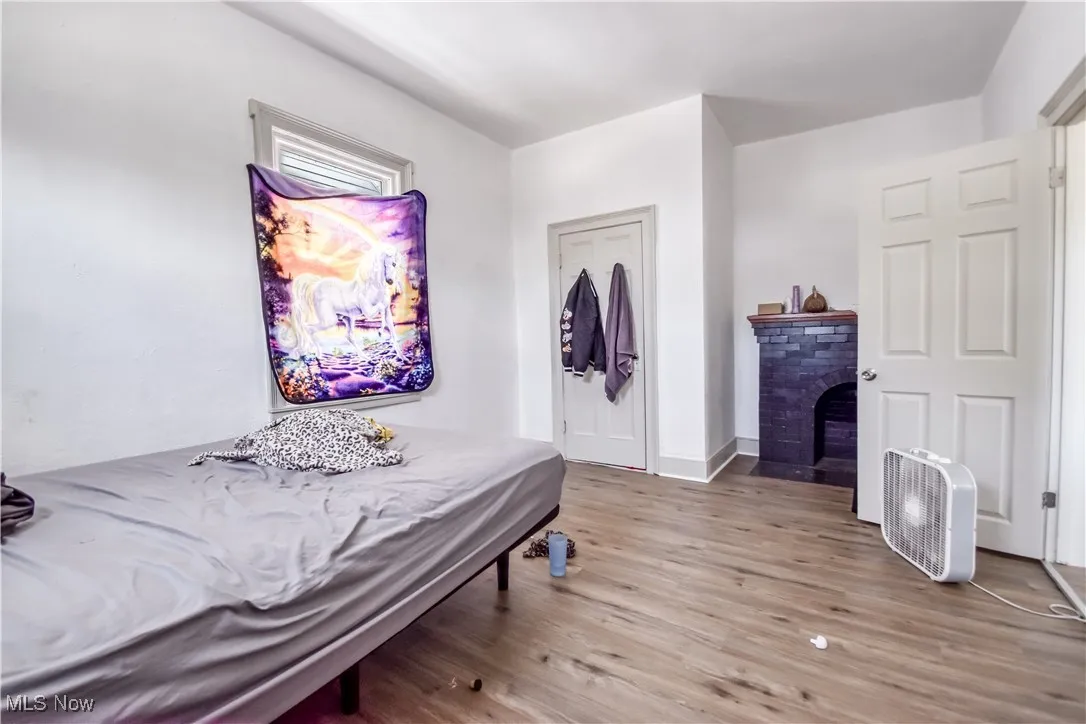 Bedroom featuring light wood-style floors and a fireplace