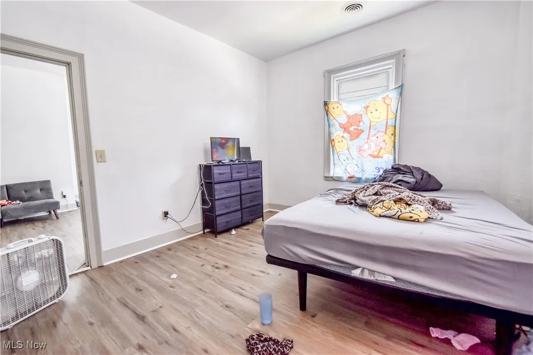 Bedroom featuring wood finished floors and baseboards