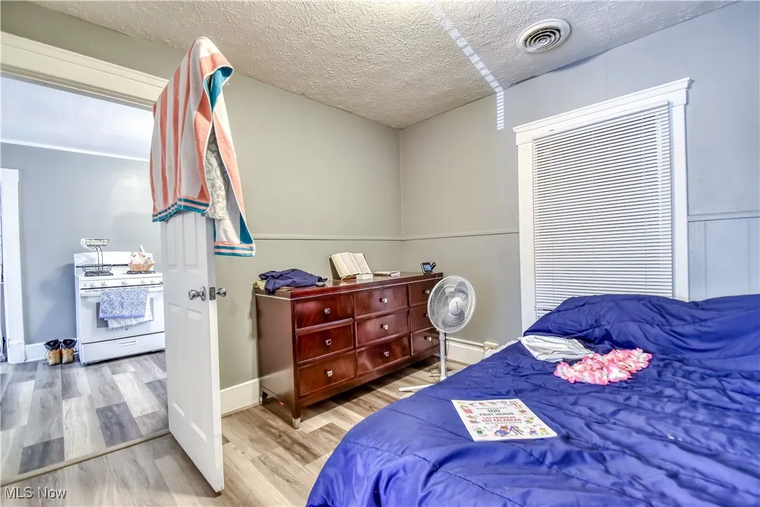 Bedroom with wood finished floors and a textured ceiling