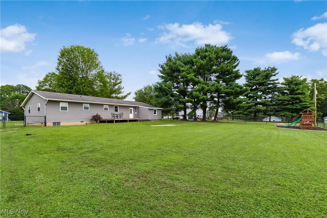 View of yard with a playground and a deck