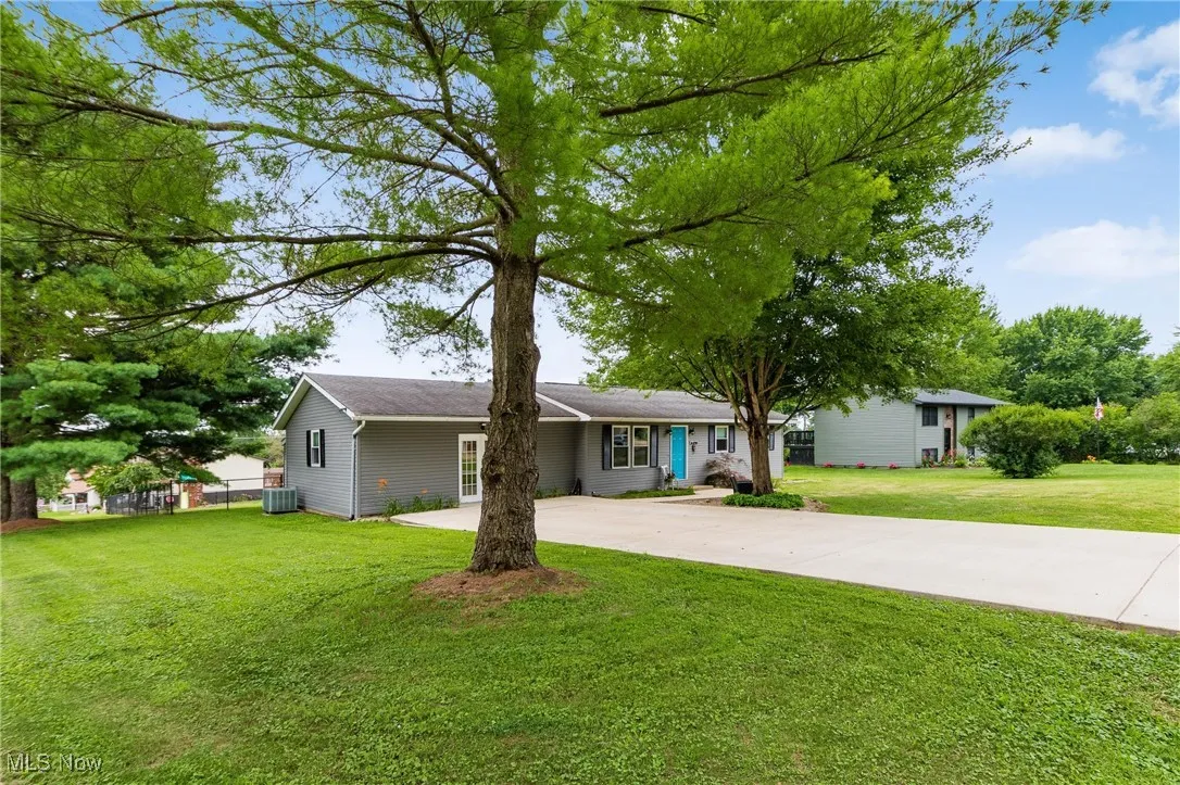 Ranch-style house with driveway and a front lawn