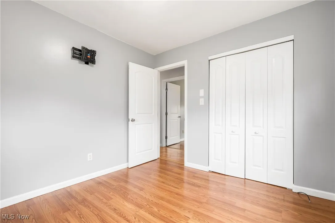 Unfurnished bedroom featuring light wood finished floors and a closet