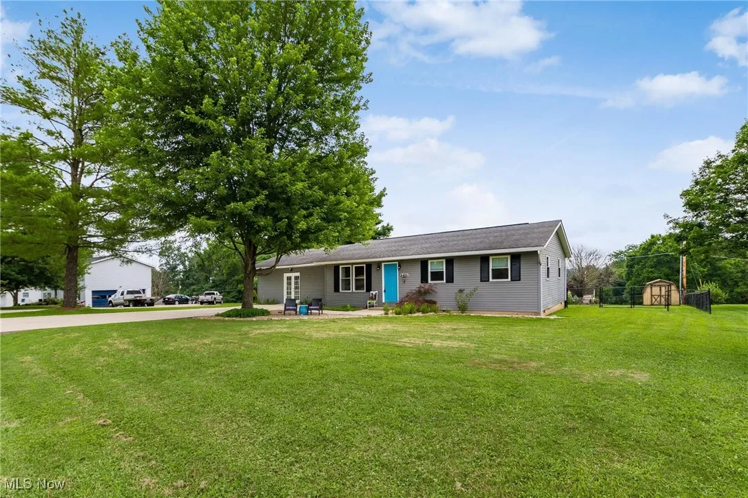 View of front of home with a front yard and a shed