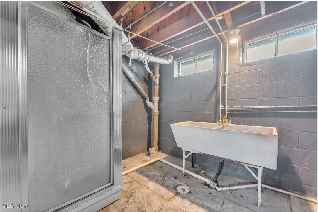 Below grade area featuring concrete block wall and a sink