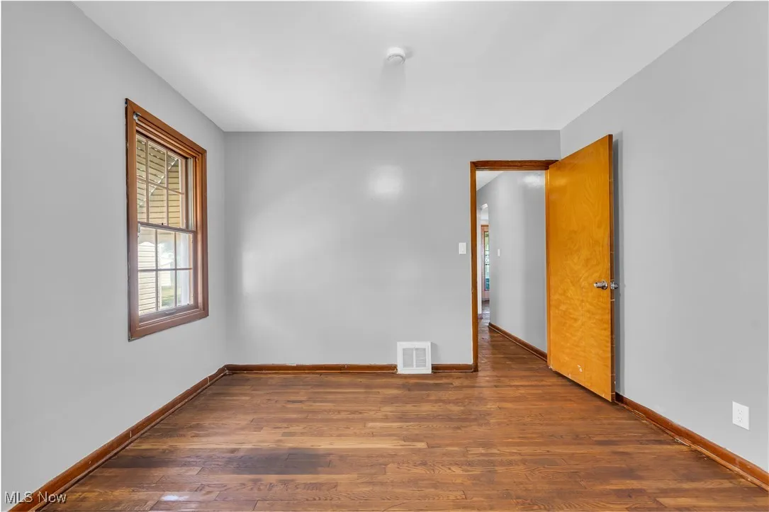 Unfurnished room featuring dark wood-style flooring
