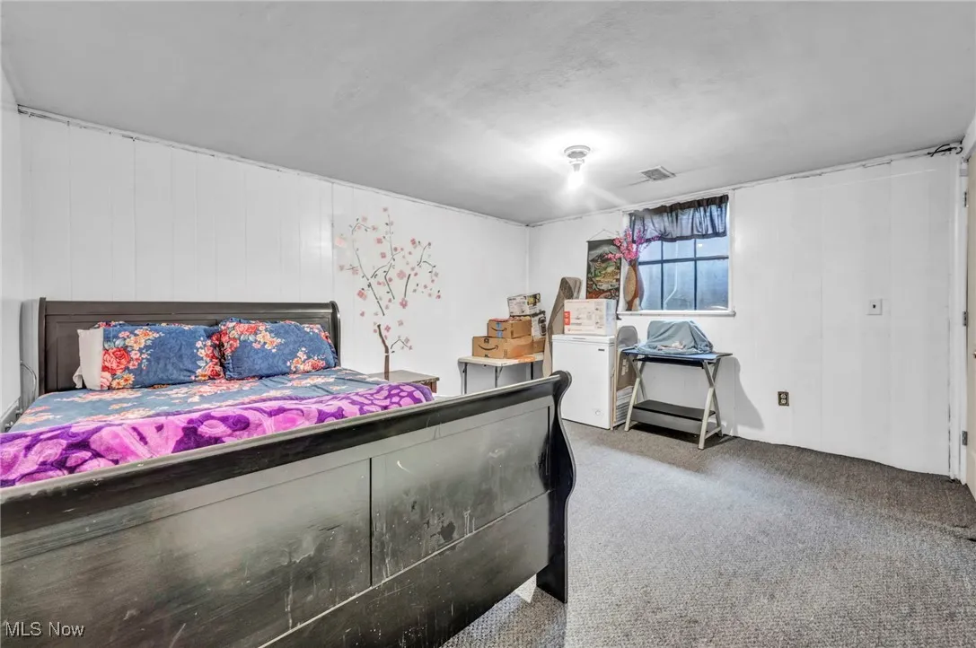 Carpeted bedroom with washer / dryer