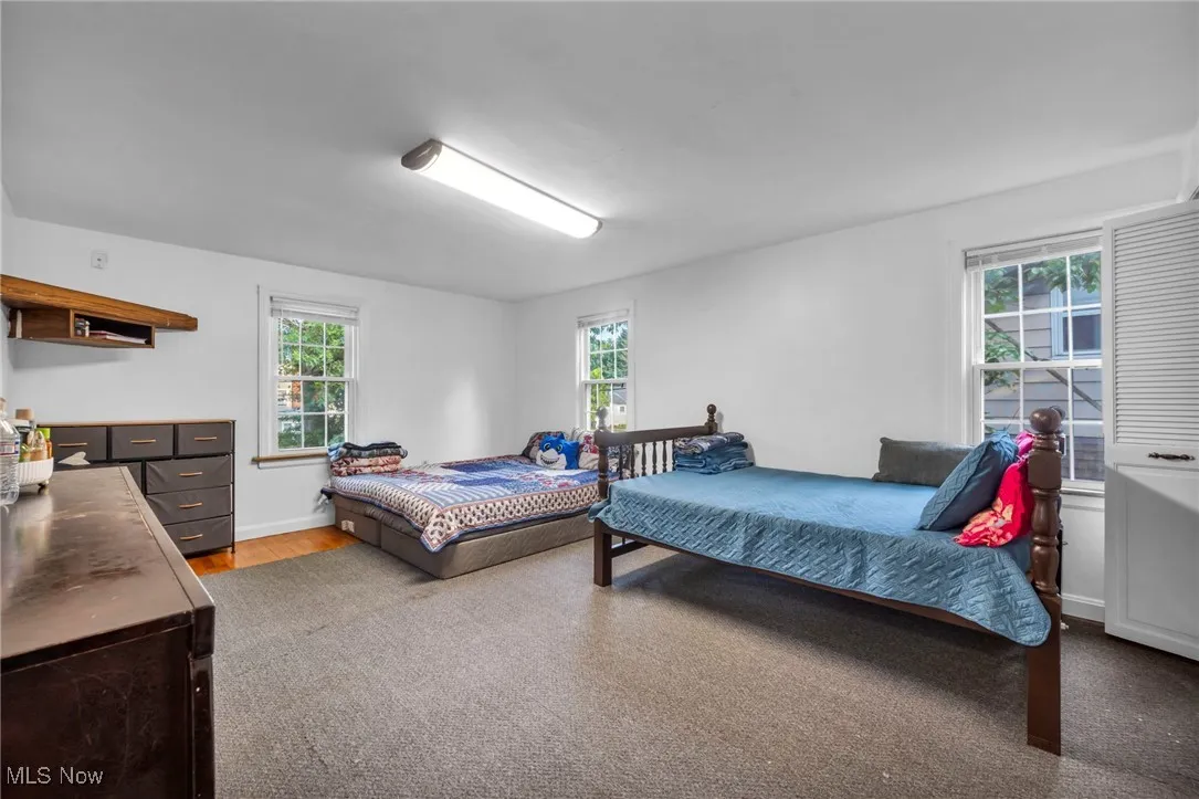 Bedroom with multiple windows and wood finished floors