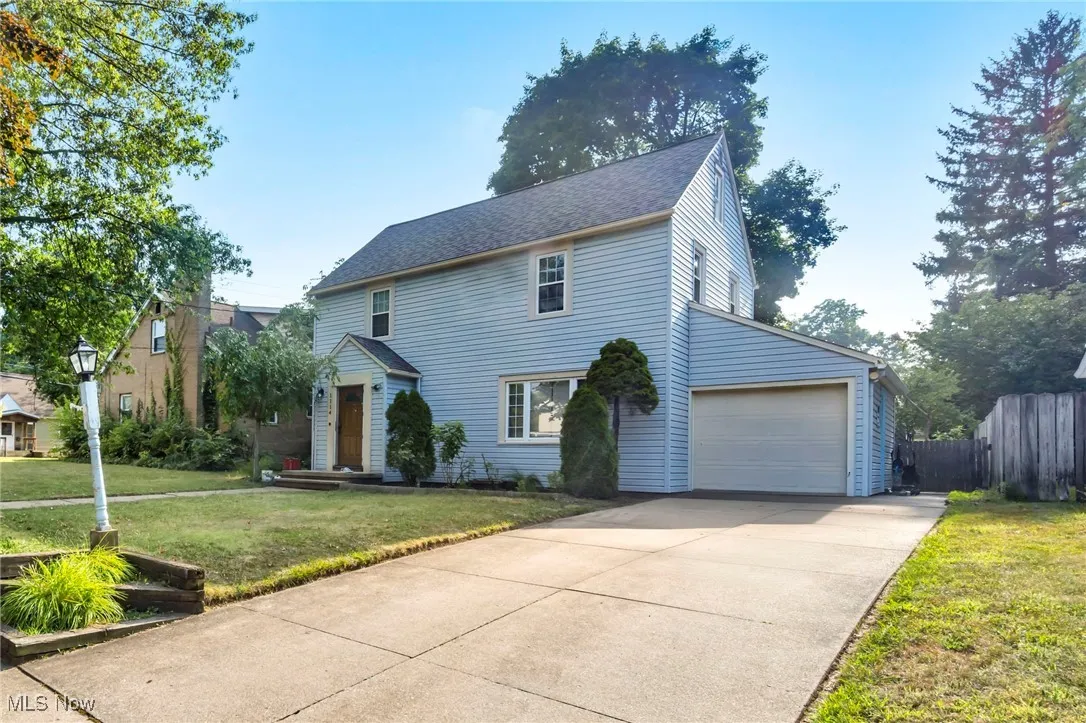 View of front of home with concrete driveway, an attached garage, and roof with shingles