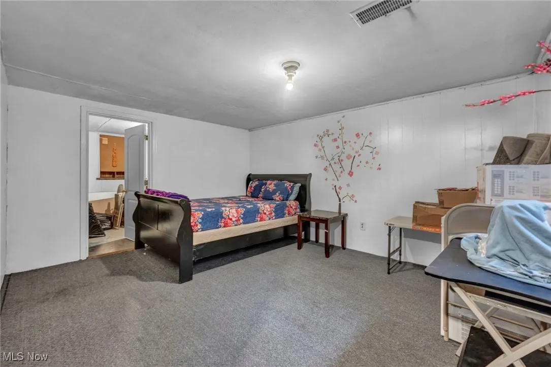 Carpeted bedroom featuring ensuite bathroom