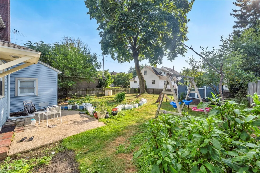 Fenced backyard featuring a playground and a patio area