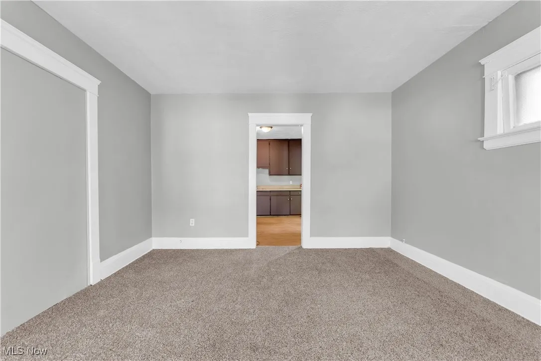 Carpeted empty room featuring baseboards
